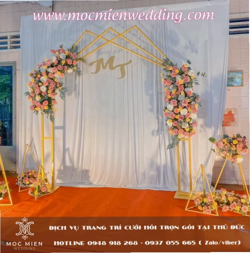 Backdrop cưới ngoài trời bằng hoa lụa và cây xanh