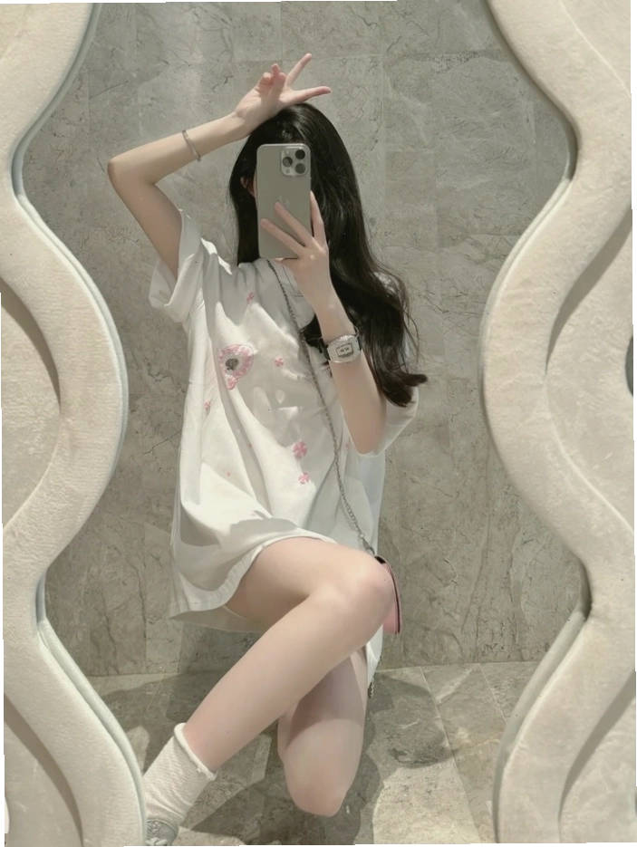 Cô gái xinh selfie trước gương và dùng điện thoại che mặt